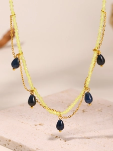 Detailed view of bohemian double-layered necklace with yellow beads and blue teardrops