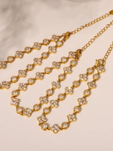 Detailed shot of gold flower bracelet featuring cubic zirconia and lobster clasp