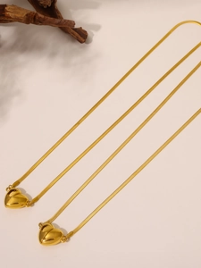 Macro del ciondolo a cuore magnetico placcato oro su catena a serpente piatta