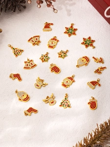Detail shot of gold-plated Christmas charms with red, green, and white zircon settings