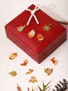 Close-up of Christmas themed rhinestone pendants on a festive gift box background