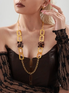 Close-up of a long gold necklace with leopard print blocks and matching earrings