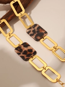 Close-up of leopard print resin blocks and gold stainless steel chain links sweater necklace