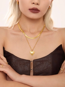 Detail of 18K gold-plated double-layer necklace with heart pendant on a model