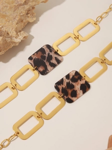 Macro detail of 18K gold-plated sweater chain with acrylic leopard print square links