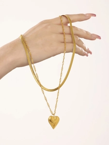 Detail of layered gold snake chain and cable chain with polished heart pendant