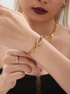 Gros plan d'un bracelet doré avec maillons sertis de zircons sur le poignet