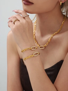Détail d'une parure en or avec zircons micro-paves sur le cou et le poignet du mannequin