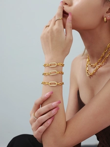 Détails d'un ensemble de bijoux dorés avec maillons ovales pavés de zircons et bracelet chic