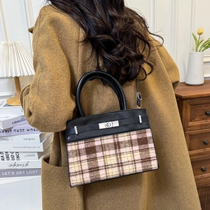Winterse handtas van leer en tweed met zilveren draaisluiting in een gezellige setting