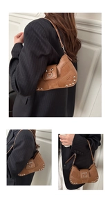 Brown leather underarm bag with silver rivet details and metallic D-ring buckle