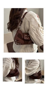 Macro shot of silver studs and embossed JINGPIN logo on brown leather underarm bag