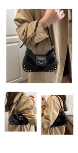 Detailed close-up of a black leather underarm bag featuring silver rivets and metal hardware
