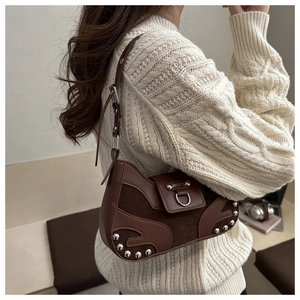 Close-up of brown vintage underarm bag featuring silver rivets and metal ring buckle