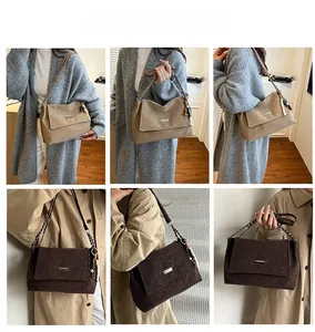 Detail view of khaki and dark brown chain tote bags with pearl charm on shoulder strap