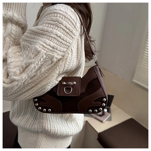 Detail of vintage brown shoulder bag with silver rivet studs and textured leather stitching