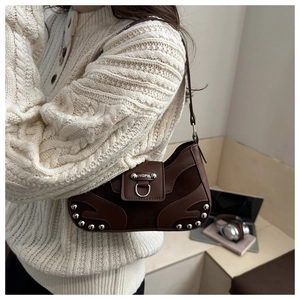 Detail of vintage brown leather crescent bag with silver rivets and metal rings