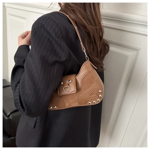 Detail of brown vintage crescent shoulder bag with metallic rivets and textured leather
