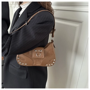 Detail of vintage brown leather bag with silver rivets and metallic buckle clasp
