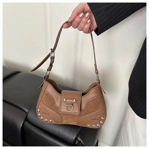 Detail of a brown leather crescent shoulder bag with silver studs and a metal buckle