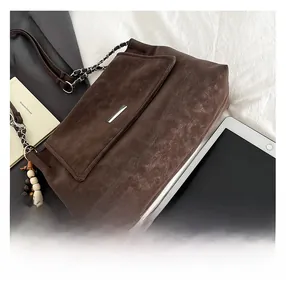 Detail of vintage brown tote bag with metal trim showing tablet storage capacity