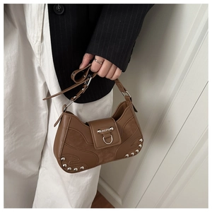 Detail of coffee brown retro underarm bag with silver rivets and polished metal ring