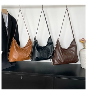 Three leather hobo bags in caramel, black and dark coffee with embossed round logo detail