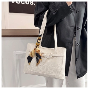 Detail of white crocodile embossed tote bag with vintage scarf and decorative side buckle