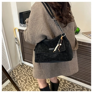 Détail d'un sac cabas noir texturé avec glands en perles de bois vintage et chaîne argentée