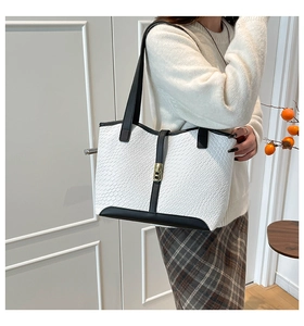 Detail of woven texture tote bag with black and white contrast and gold metal clasp