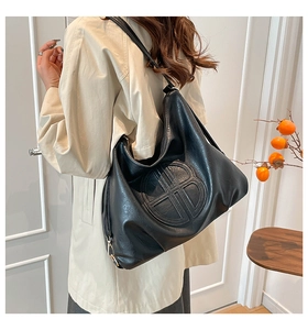 Dettaglio della borsa a tracolla vintage in pelle PU nera con logo a rilievo e finiture oro