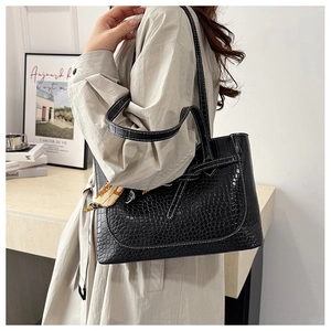 Detail of black crocodile texture tote bag with a colorful printed silk scarf on strap