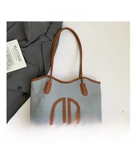Macro detail of tote bag showing woven fabric texture and brown leather round AB logo