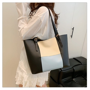 Macro detail of tricolor patchwork tote bag with gold metal buckle on adjustable strap