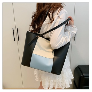 Three-color contrast leather tote bag styled on model for chic commute and casual use