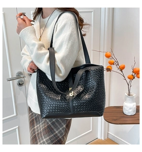 Detail van zwarte geweven shopper met Intrecciato-patroon en gouden metalen gesp