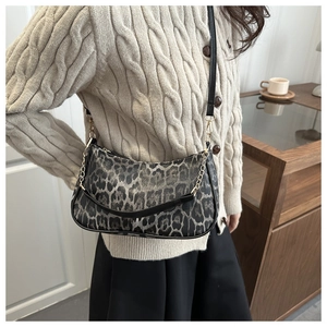 Dettaglio della borsa leopardata con catena dorata e texture in pelle liscia