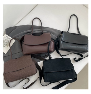 Close-up of stylish tote bags in smooth and suede finishes with minimalist flap closure