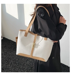 Detail of white woven leather tote bag with khaki straps and metallic gold buckle
