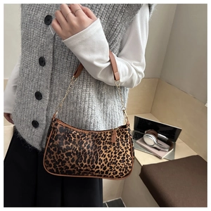 Dettaglio borsa baguette leopardata con tracolla in pelle marrone e catena dorata