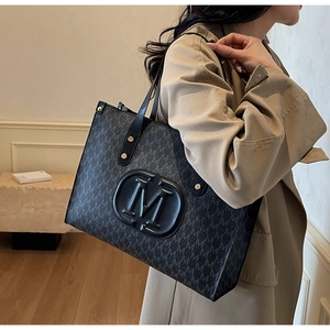 Detail of PU leather tote bag with M-pattern print on beige trench coat model