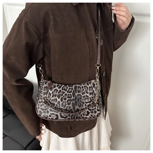 Dettaglio della borsa leopardata con catena dorata e trama in pelle scamosciata