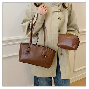 Detail of brown faux leather tote and matching pouch set with vintage texture