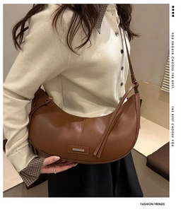Vue détaillée d'un sac demi-lune marron foncé avec boucle en métal et bandoulière cuir