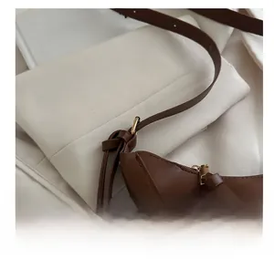 Détail macro d'un sac bandoulière en cuir marron avec boucle en métal doré réglable