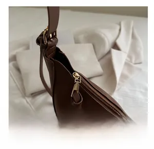 Détail de la fermeture éclair fluide d'un sac demi-lune en cuir marron chic