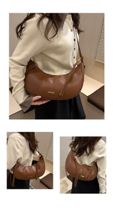 Detail showing vintage brown crescent bag with gold metal plate and long zip tassels