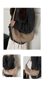 Detail view of apricot crescent bag with long fringe tassels and metal bar buckle decoration