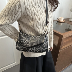 Borsa a tracolla leopardata alla moda con catena dorata in un ambiente domestico chic
