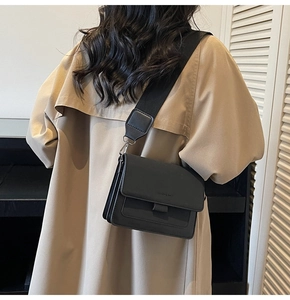 Close-up of black crossbody bag with wide strap and Fashion & Bags embossed lettering